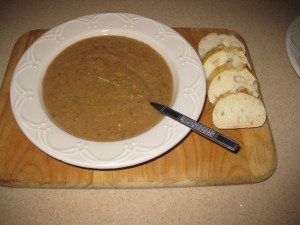 White bowl filled with Chestnut Soup accompanied by homemade bread.