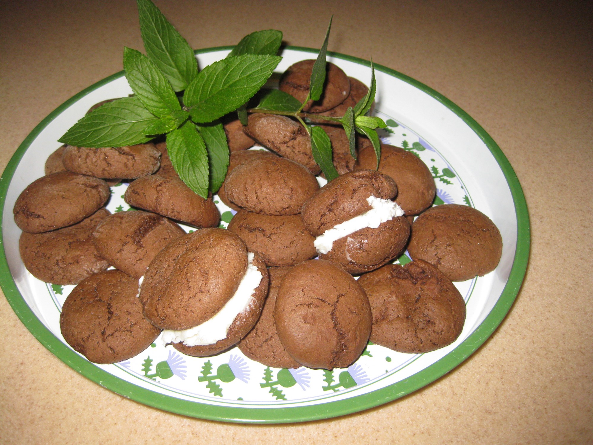 Chocolate mint cookies on a tray decorated with mint leaves.