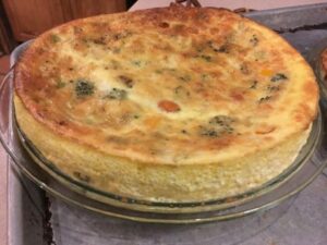 A crustless quiche filled with vegetables and hot out of the oven.